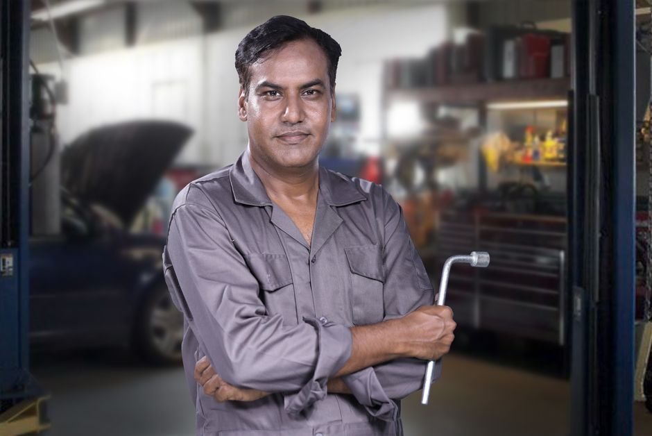 Friendly automotive mechanic assisting a customer