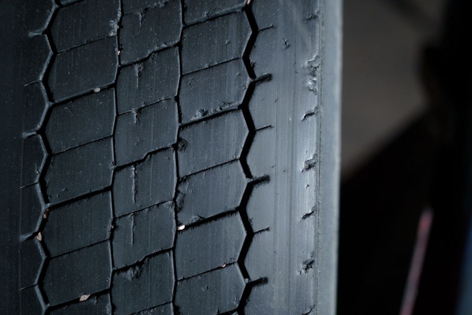 Technician checking tire tread depth and wear